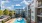 Aerial view of the pool area at Eleven North Apartments, showcasing the large swimming pool surrounded by lounge chairs and neatly arranged landscaping